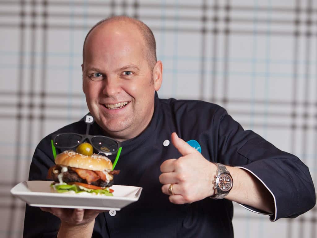 Garner Andrews from Sonic 102.9 poses with his celebrity burger creation for Delux Burger's Celebrity Chef campaign